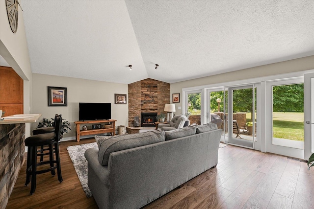 2911 E Oaks Rd N, Urbana, IL 61802 - living room with vaulted ceiling, a stone fireplace, a textured ceiling, and wood finished floors