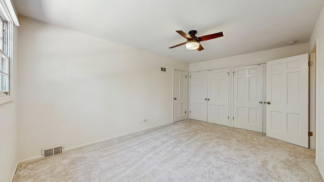 39 Keswick Ct, Lincolnshire, IL 60069 - unfurnished bedroom with multiple closets, carpet flooring, and a ceiling fan