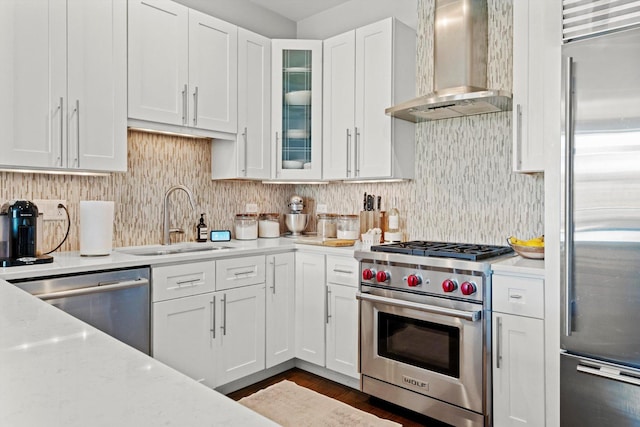 2140 W Armitage Ave Unit 3W, Chicago, IL 60647 - kitchen with wall chimney exhaust hood, premium appliances, white cabinetry, and glass insert cabinets