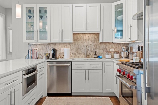 2140 W Armitage Ave Unit 3W, Chicago, IL 60647 - kitchen with high end appliances, white cabinets, light countertops, decorative backsplash, and dark wood-type flooring