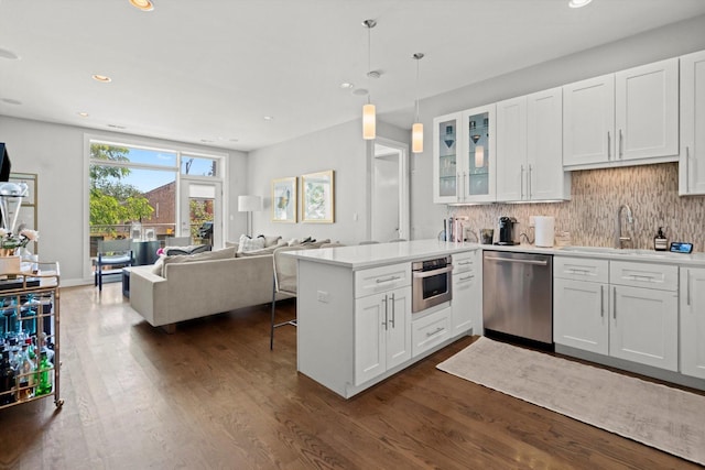 2140 W Armitage Ave Unit 3W, Chicago, IL 60647 - kitchen with appliances with stainless steel finishes, open floor plan, a peninsula, dark wood-style floors, and backsplash