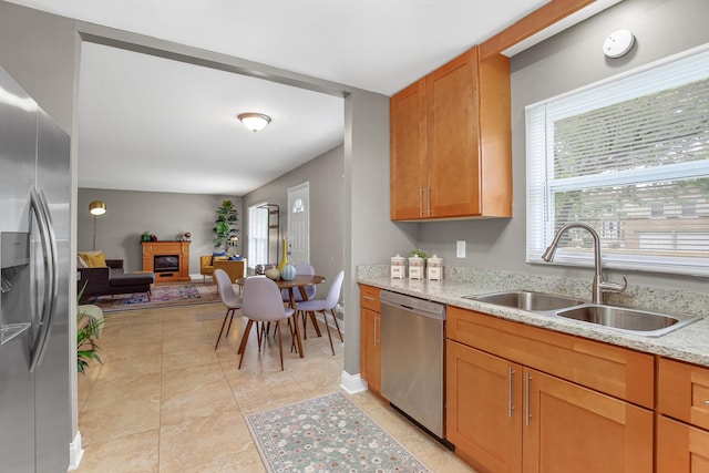 17711 Country Club Ln, Country Club Hills, IL 60478 - kitchen featuring appliances with stainless steel finishes, a glass covered fireplace, light stone counters, and light tile patterned floors