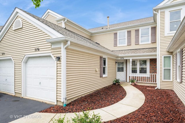 276 Greensboro Ct, Elk Grove Village, IL 60007 - view of property exterior featuring driveway, roof with shingles, covered porch, and an attached garage