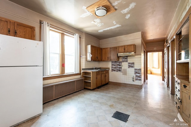 2339 S 61st Ave, Cicero, IL 60804 - kitchen featuring freestanding refrigerator, radiator heating unit, brown cabinets, under cabinet range hood, and open shelves
