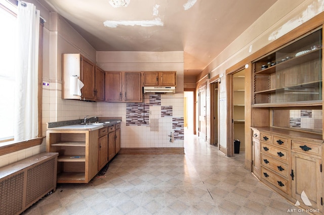 2339 S 61st Ave, Cicero, IL 60804 - kitchen featuring radiator, open shelves, under cabinet range hood, light flooring, and brown cabinets