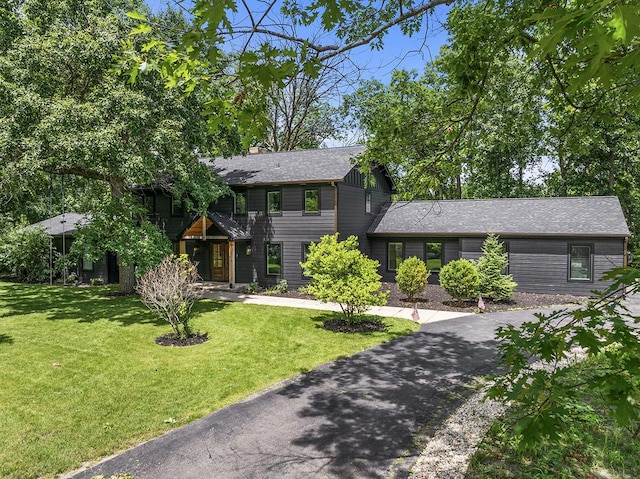 692 S Waukegan Rd, Lake Forest, IL 60045 - view of front of home with a front lawn, a chimney, a shingled roof, and driveway