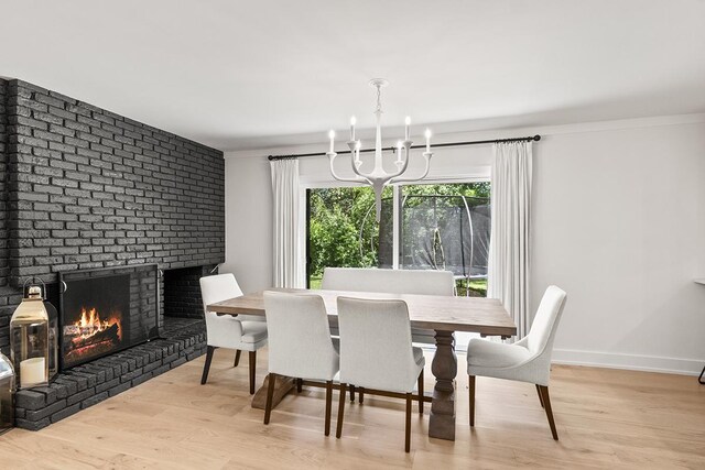 692 S Waukegan Rd, Lake Forest, IL 60045 - dining room featuring a chandelier, wood finished floors, and a brick fireplace