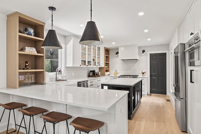 692 S Waukegan Rd, Lake Forest, IL 60045 - kitchen featuring open shelves, custom exhaust hood, a peninsula, light wood finished floors, and white cabinetry