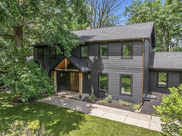 692 S Waukegan Rd, Lake Forest, IL 60045 - view of front of property with a front yard, a chimney, and roof with shingles
