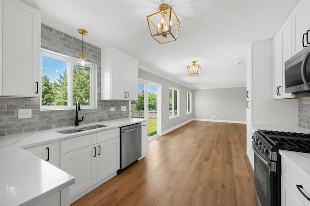 14530 General Dr, Plainfield, IL 60544 - kitchen with appliances with stainless steel finishes, a chandelier, light wood-type flooring, backsplash, and white cabinets