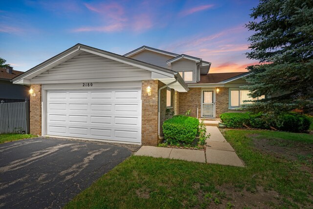 2180 Newport Cir, Hanover Park, IL 60133 - traditional-style home featuring brick siding, asphalt driveway, and a garage