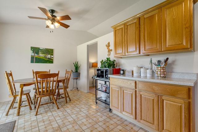 2180 Newport Cir, Hanover Park, IL 60133 - kitchen with light countertops, a ceiling fan, lofted ceiling, brown cabinetry, and light floors