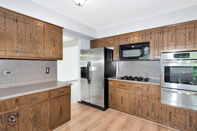 14332 S W Glen Dr, Homer Glen, IL 60491 - kitchen with stainless steel appliances, a warming drawer, backsplash, light wood-type flooring, and light countertops