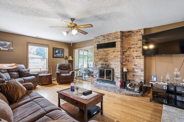 2612 Valkar Ln, Champaign, IL 61822 - living room with a ceiling fan, wood finished floors, plenty of natural light, a textured ceiling, and a brick fireplace