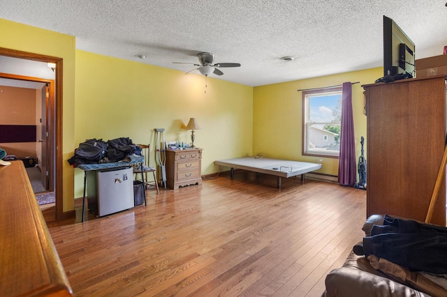 2612 Valkar Ln, Champaign, IL 61822 - playroom with ceiling fan, hardwood / wood-style floors, a textured ceiling, and a baseboard radiator