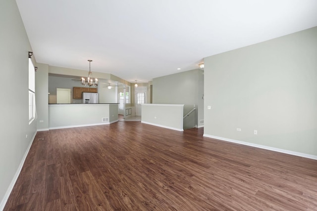 13245 Honeysuckle Dr, Huntley, IL 60142 - unfurnished living room with a chandelier and dark wood finished floors