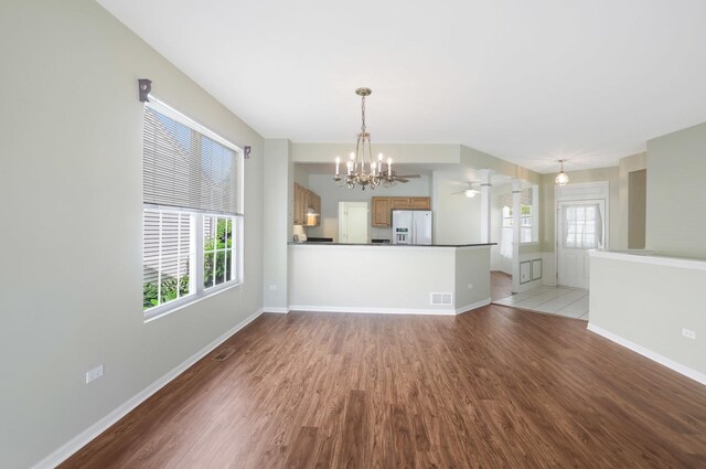 13245 Honeysuckle Dr, Huntley, IL 60142 - unfurnished living room with wood finished floors and a chandelier
