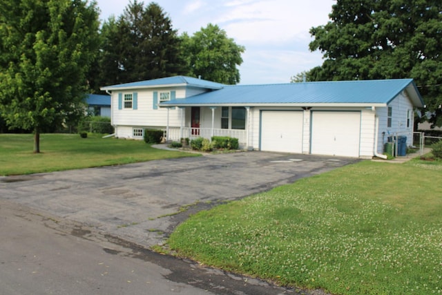 819 S W St, Earlville, IL 60518 - tri-level home with asphalt driveway, an attached garage, covered porch, a front lawn, and a metal roof