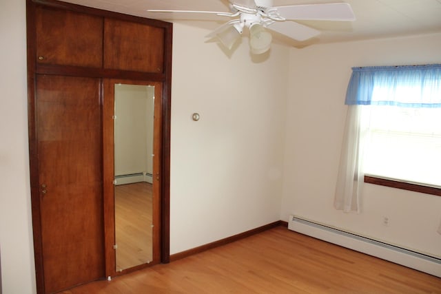 819 S W St, Earlville, IL 60518 - unfurnished bedroom featuring baseboard heating, light wood-style flooring, and ceiling fan