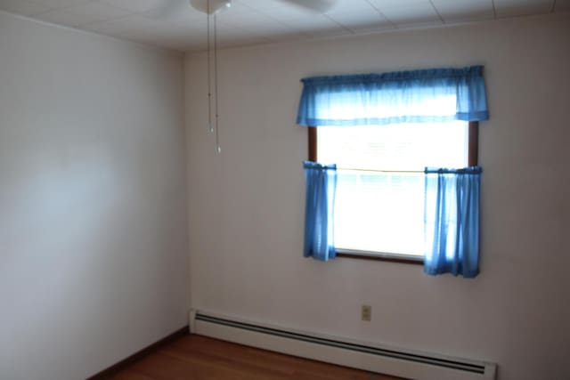 819 S W St, Earlville, IL 60518 - spare room with a baseboard radiator and wood finished floors