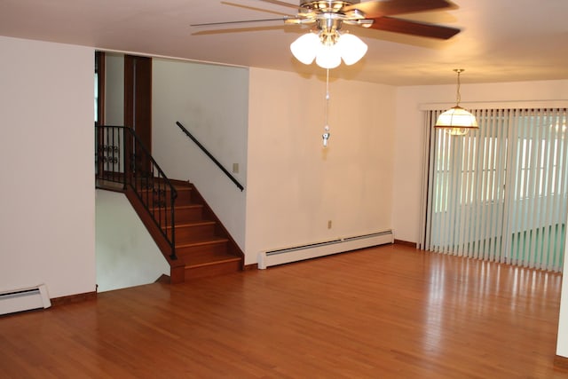819 S W St, Earlville, IL 60518 - unfurnished living room featuring baseboard heating, ceiling fan, and wood finished floors