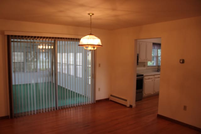 819 S W St, Earlville, IL 60518 - unfurnished dining area with a baseboard heating unit, a chandelier, and dark wood-style floors