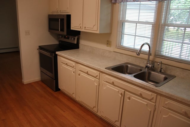 819 S W St, Earlville, IL 60518 - kitchen with appliances with stainless steel finishes, white cabinets, light wood-type flooring, and light countertops