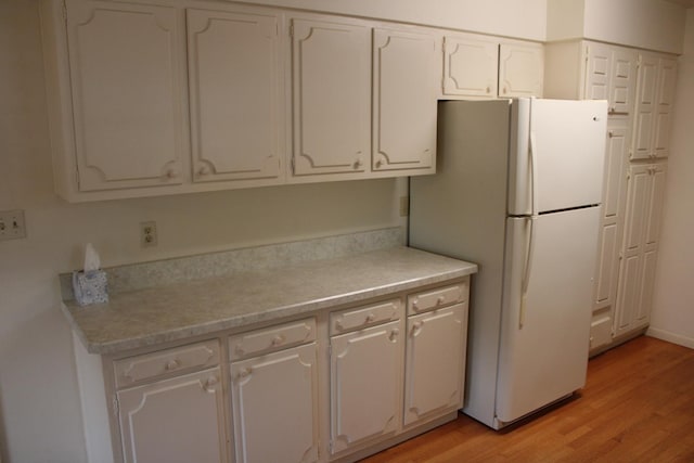 819 S W St, Earlville, IL 60518 - kitchen featuring freestanding refrigerator, white cabinetry, light wood finished floors, and light countertops