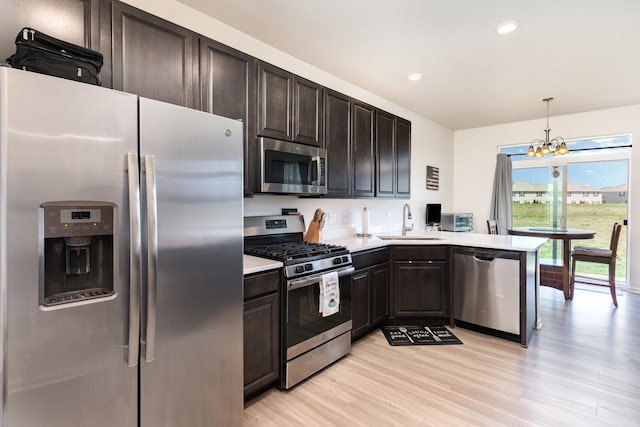 15135 W Quincy Cir, Manhattan, IL 60442 - kitchen with stainless steel appliances, a chandelier, light countertops, light wood-style flooring, and hanging light fixtures