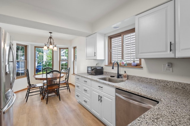 96 Townsend Cir, Naperville, IL 60565 - kitchen with appliances with stainless steel finishes, light wood-style flooring, white cabinetry, light stone countertops, and hanging light fixtures