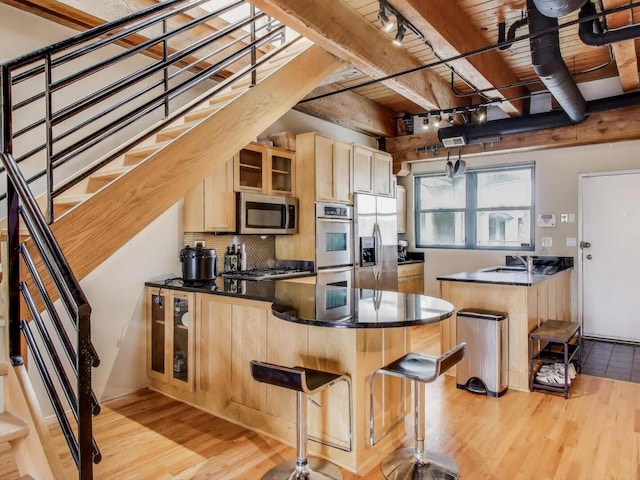 1740 N Marshfield Ave Unit 30, Chicago, IL 60622 - kitchen with a peninsula, appliances with stainless steel finishes, a wooden ceiling with exposed beams, light brown cabinetry, and track lighting