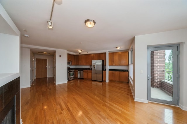 9360 Skokie Blvd Unit 414, Skokie, IL 60077 - kitchen with stainless steel appliances, brown cabinetry, light wood finished floors, and dark countertops