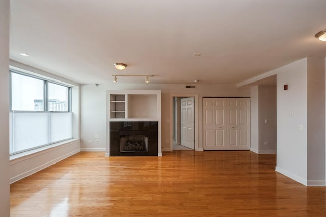 9360 Skokie Blvd Unit 414, Skokie, IL 60077 - unfurnished living room featuring a fireplace and light wood-style floors