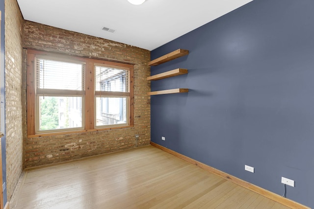 1225 W Greenleaf Ave Unit 3E, Chicago, IL 60626 - unfurnished room featuring wood finished floors, brick wall, and healthy amount of natural light