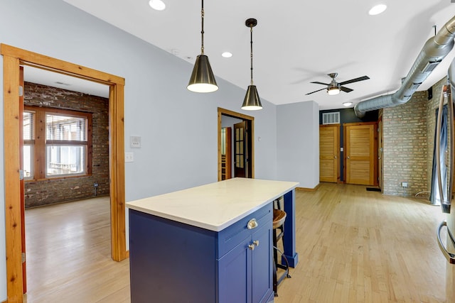 1225 W Greenleaf Ave Unit 3E, Chicago, IL 60626 - kitchen with brick wall, blue cabinetry, ceiling fan, light wood-style flooring, and light countertops