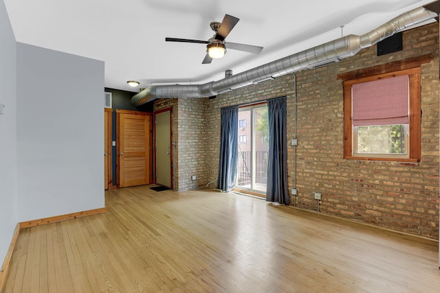 1225 W Greenleaf Ave Unit 3E, Chicago, IL 60626 - unfurnished room with brick wall, wood finished floors, and a ceiling fan