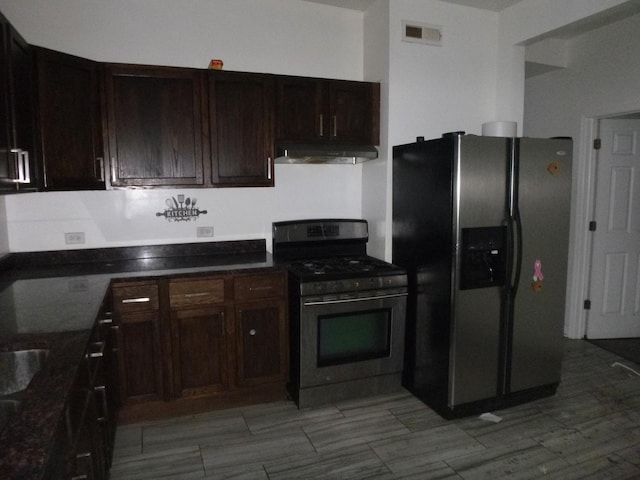 1528 S Spaulding Ave, Chicago, IL 60623 - kitchen featuring appliances with stainless steel finishes, under cabinet range hood, dark stone counters, and dark brown cabinets