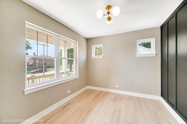 4947 Wilcox Ave, Downers Grove, IL 60515 - unfurnished room with light wood-style flooring and a chandelier