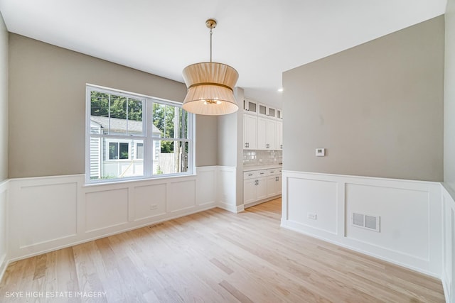 4947 Wilcox Ave, Downers Grove, IL 60515 - unfurnished dining area featuring light wood-type flooring, a decorative wall, and wainscoting
