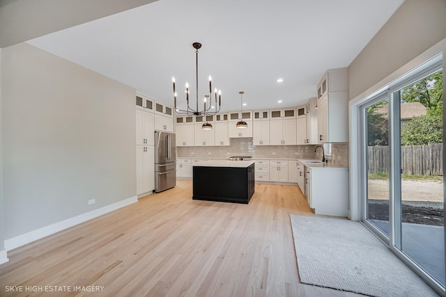 4947 Wilcox Ave, Downers Grove, IL 60515 - kitchen with freestanding refrigerator, a chandelier, a center island, decorative backsplash, and light countertops
