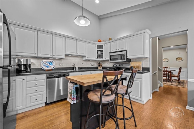 42W285 Retreat Ct Unit 2, Saint Charles, IL 60175 - kitchen with appliances with stainless steel finishes, wood counters, decorative backsplash, light wood finished floors, and a towering ceiling
