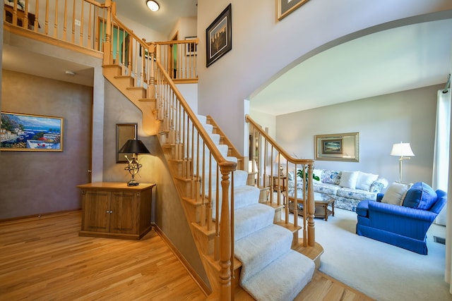 2845 Kendridge Ln, Aurora, IL 60502 - stairway featuring wood finished floors, arched walkways, and a towering ceiling