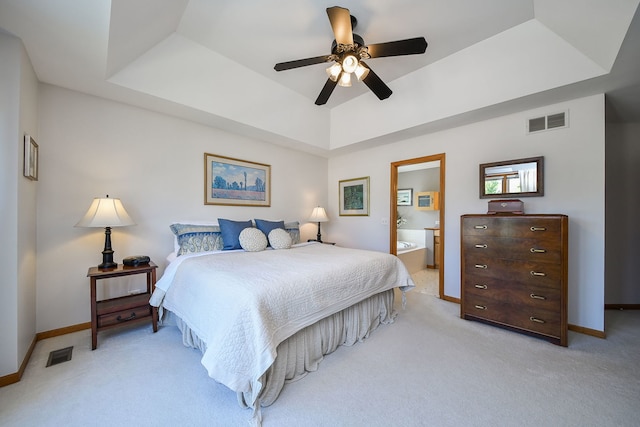 2845 Kendridge Ln, Aurora, IL 60502 - bedroom with a tray ceiling, light colored carpet, connected bathroom, and a ceiling fan