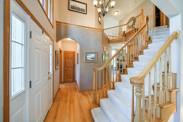 2845 Kendridge Ln, Aurora, IL 60502 - entrance foyer featuring arched walkways, a high ceiling, wood finished floors, stairs, and a chandelier