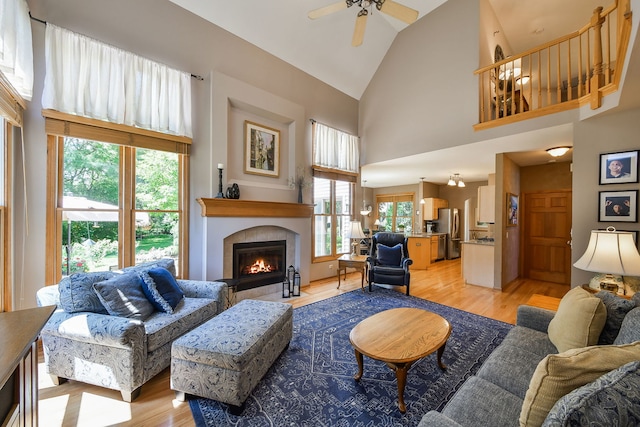 2845 Kendridge Ln, Aurora, IL 60502 - living room with high vaulted ceiling, a fireplace, a ceiling fan, and light wood-style flooring