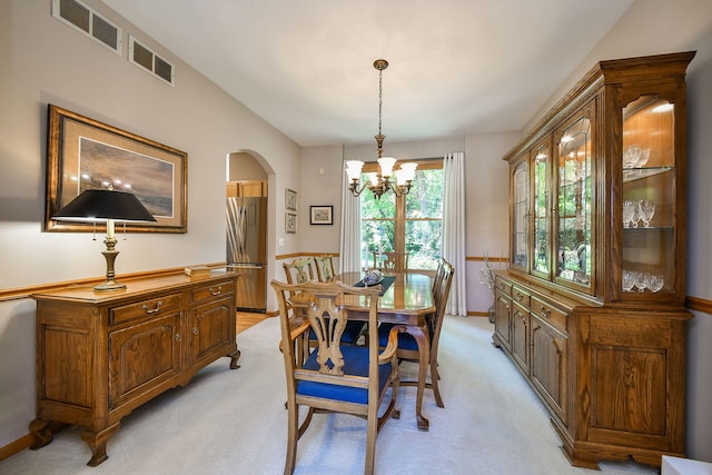 2845 Kendridge Ln, Aurora, IL 60502 - dining area with light colored carpet, arched walkways, and a chandelier