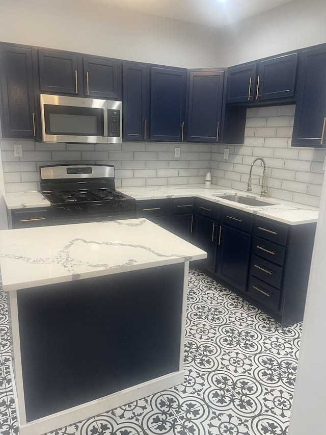 48 E 154th St, Harvey, IL 60426 - kitchen featuring stainless steel appliances, blue cabinets, light stone countertops, and tasteful backsplash
