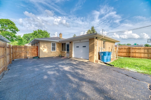 1617 Oakland Ave, Crest Hill, IL 60403 - view of front facade featuring brick siding, asphalt driveway, a chimney, an attached garage, and a fenced backyard