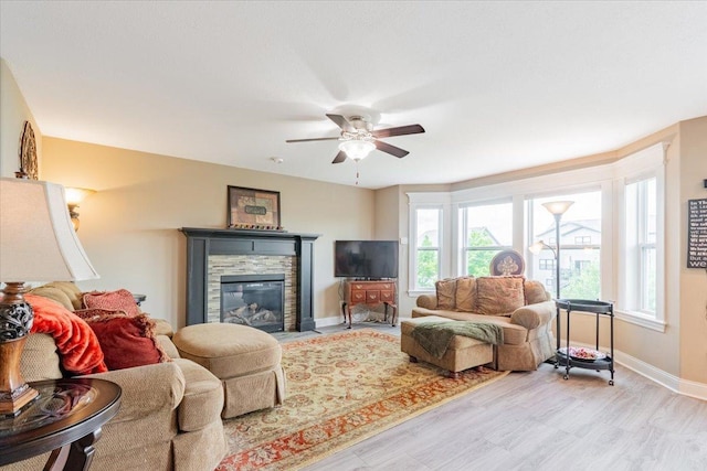 5108 Longfield Rd, Bloomington, IL 61705 - living room featuring ceiling fan, a glass covered fireplace, and light wood-type flooring