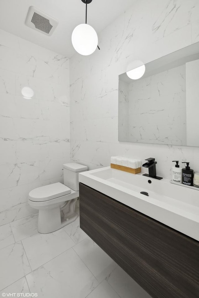 2814 W N Ave Unit 2W, Chicago, IL 60647 - bathroom with marble look tile flooring, vanity, and stone wall